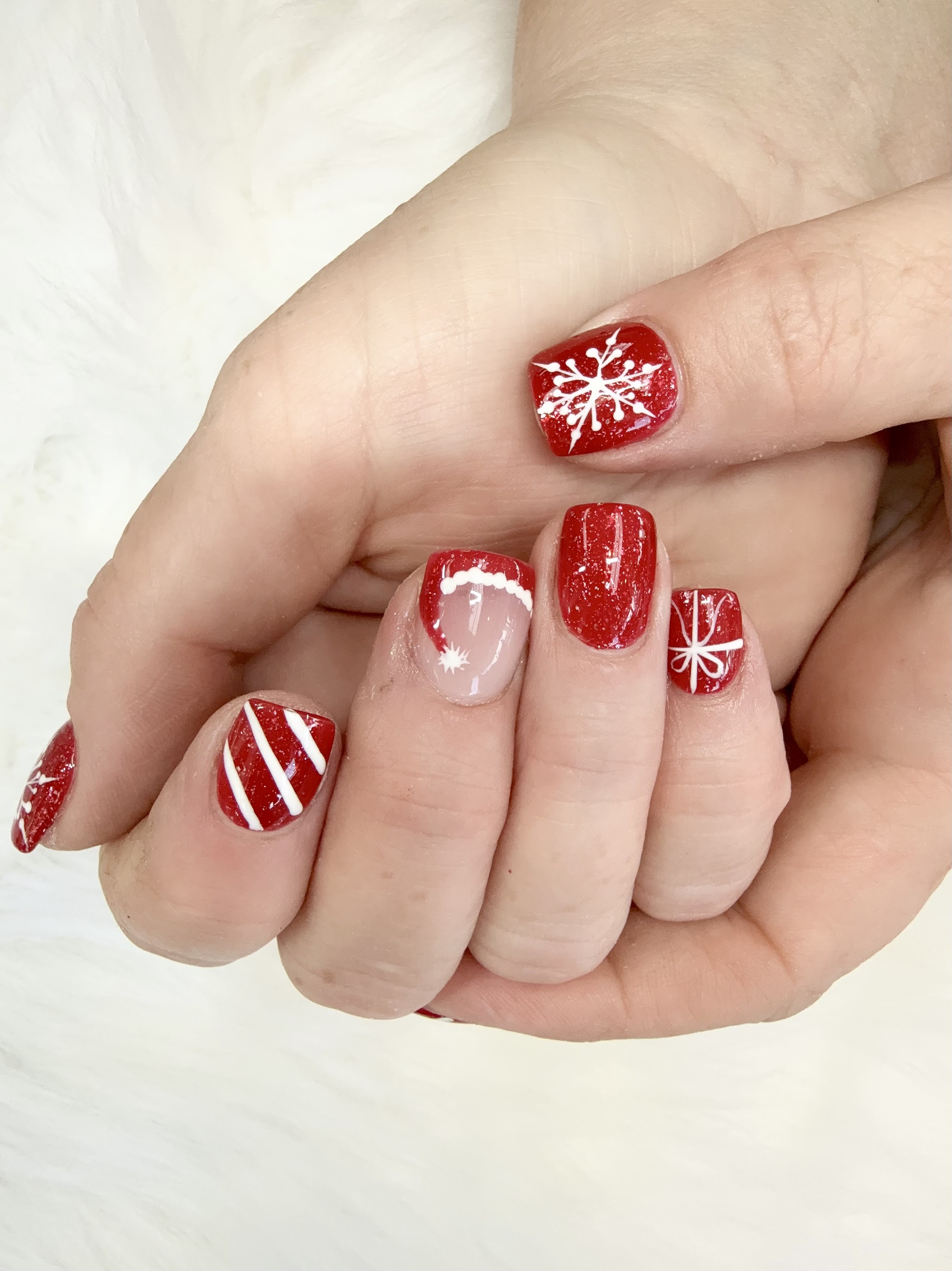 Red glitter Christmas nails with snowflakes and candy stripes